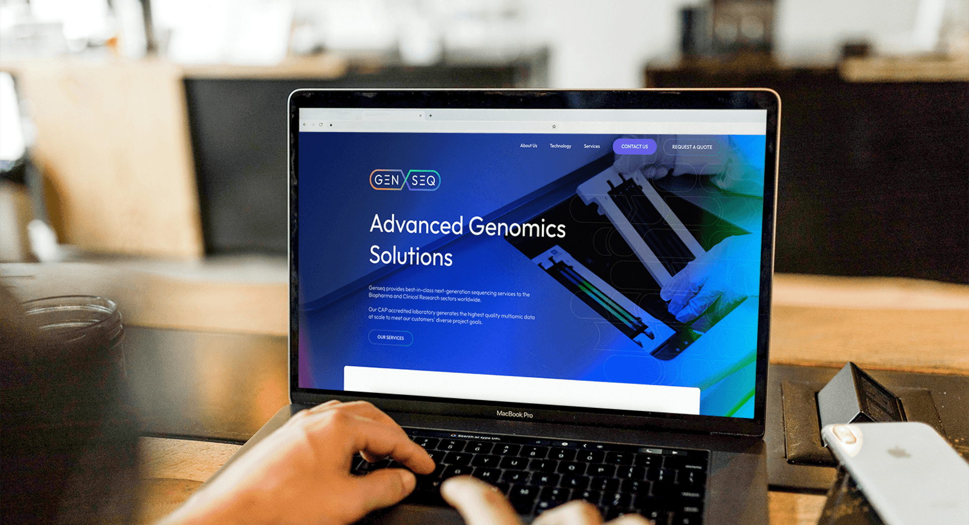A zoomed in shot of someone at their laptop looking at the Genseq website homepage.